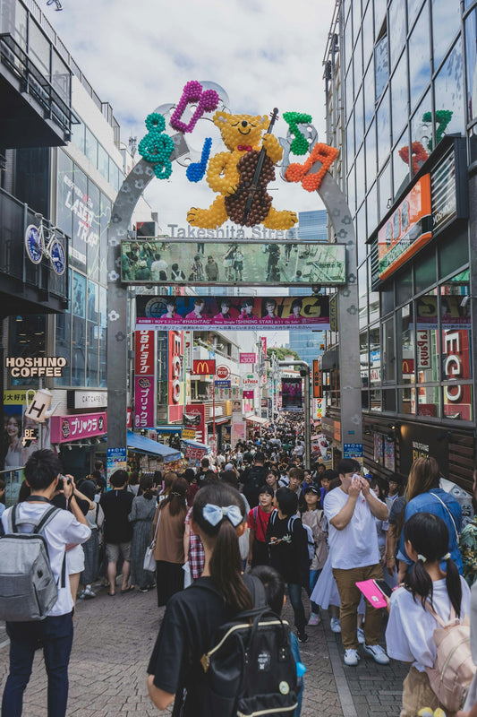 a crowd of people walking on a street with a large sign
