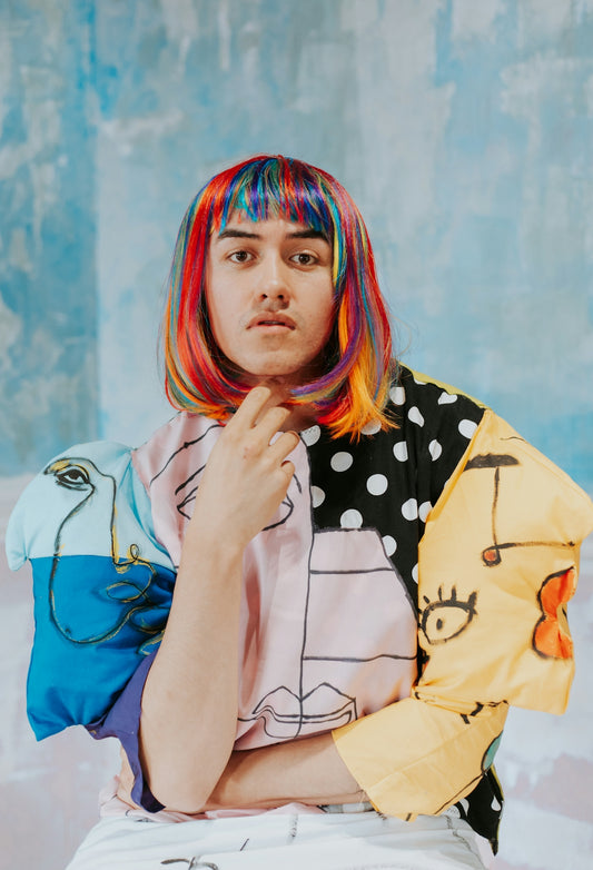 A woman with colorful hair sitting on a chair