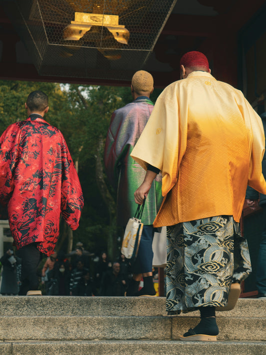 People in colorful robes enter a temple.