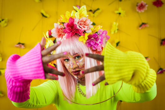 Woman poses with flowers and colorful accessories.