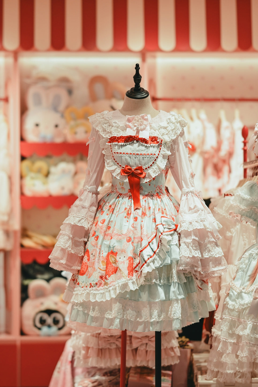 Frilly strawberry lolita dress on a mannequin in a store.