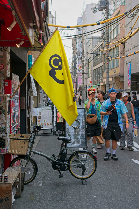 A bicycle with a yellow flag on a busy street.
